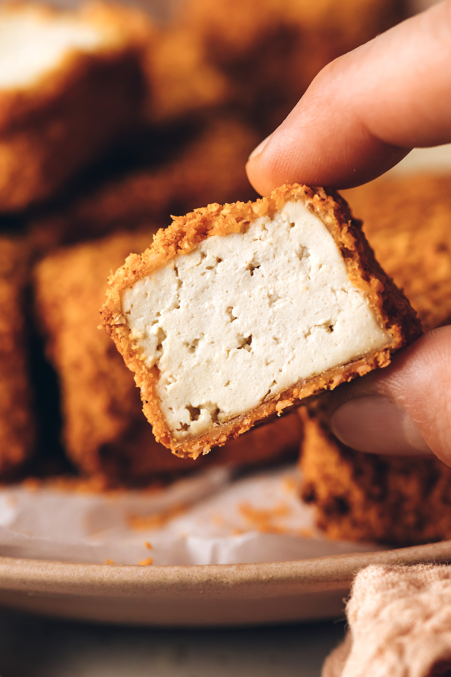 Close up photo showing the inside of a crispy tofu nugget