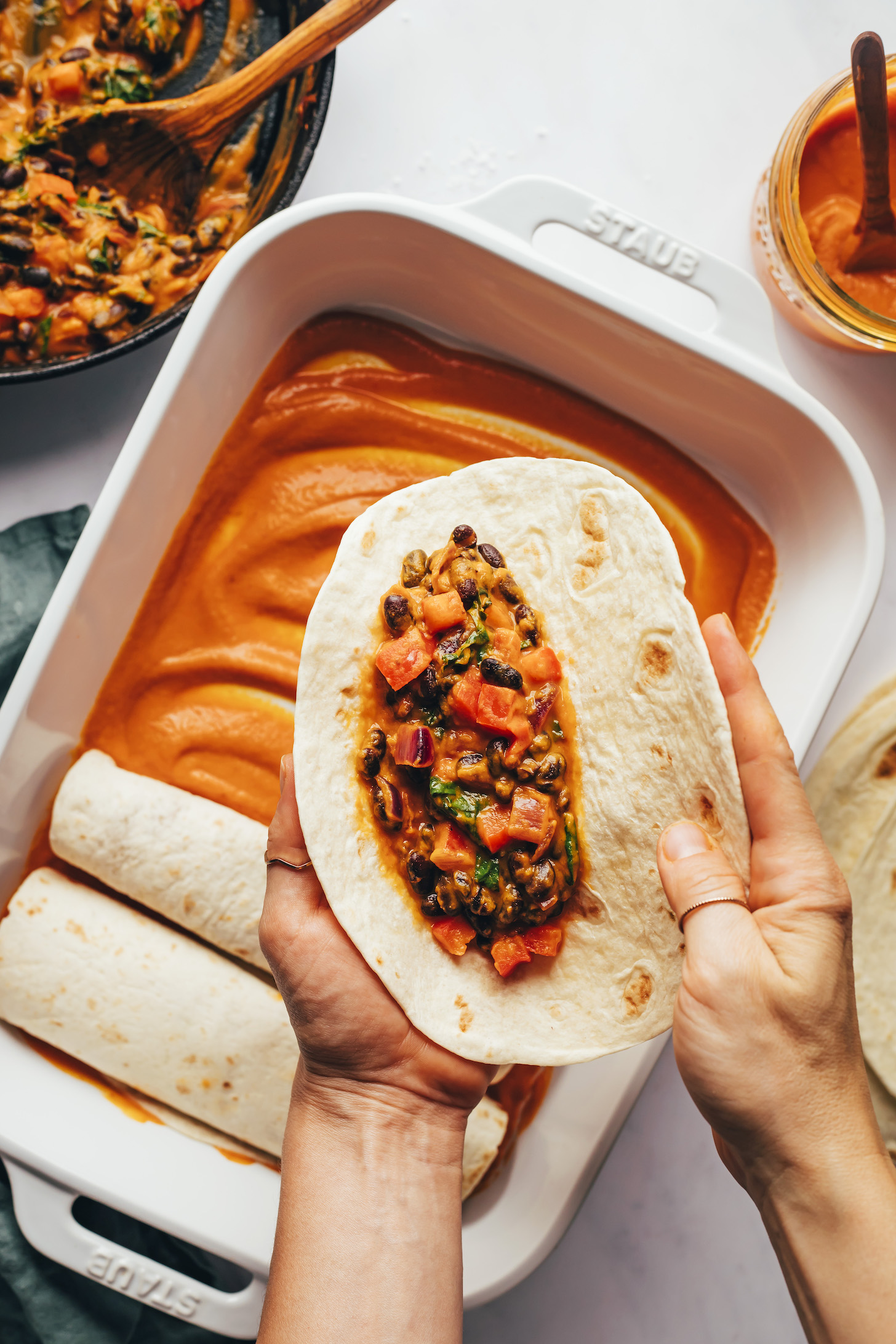 Holding a flour tortilla with a black bean veggie filling on it