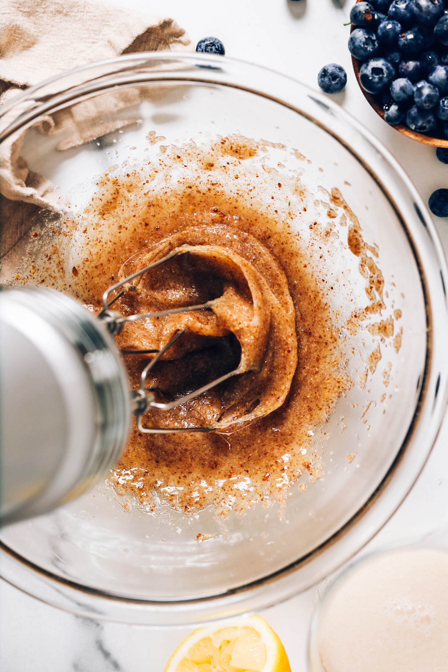 Using a hand mixer to combine flaxseed meal, water, dairy-free milk, and lemon juice
