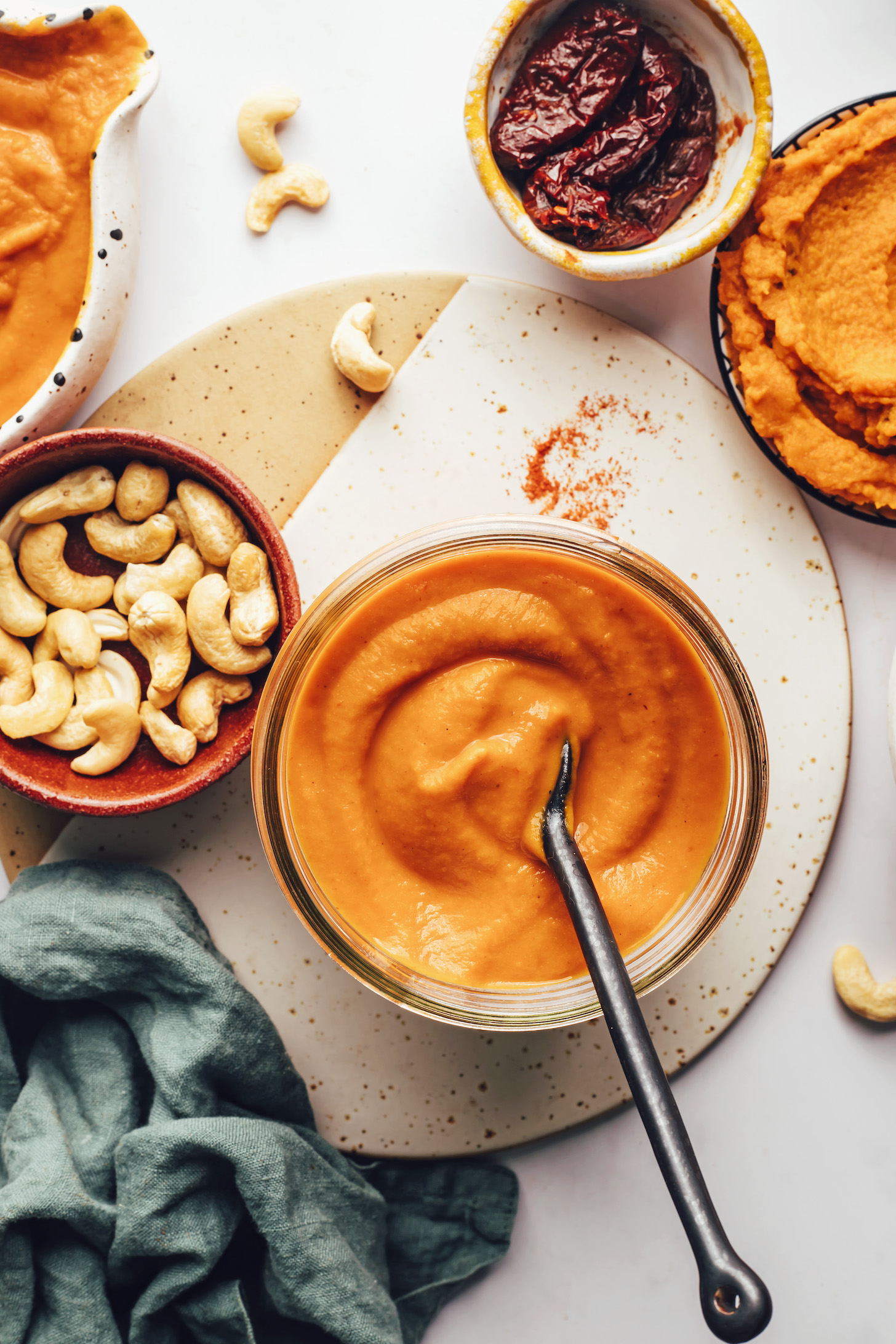 Cashews, chipotle peppers, and pumpkin purée next to a jar of our pumpkin enchilada sauce recipe