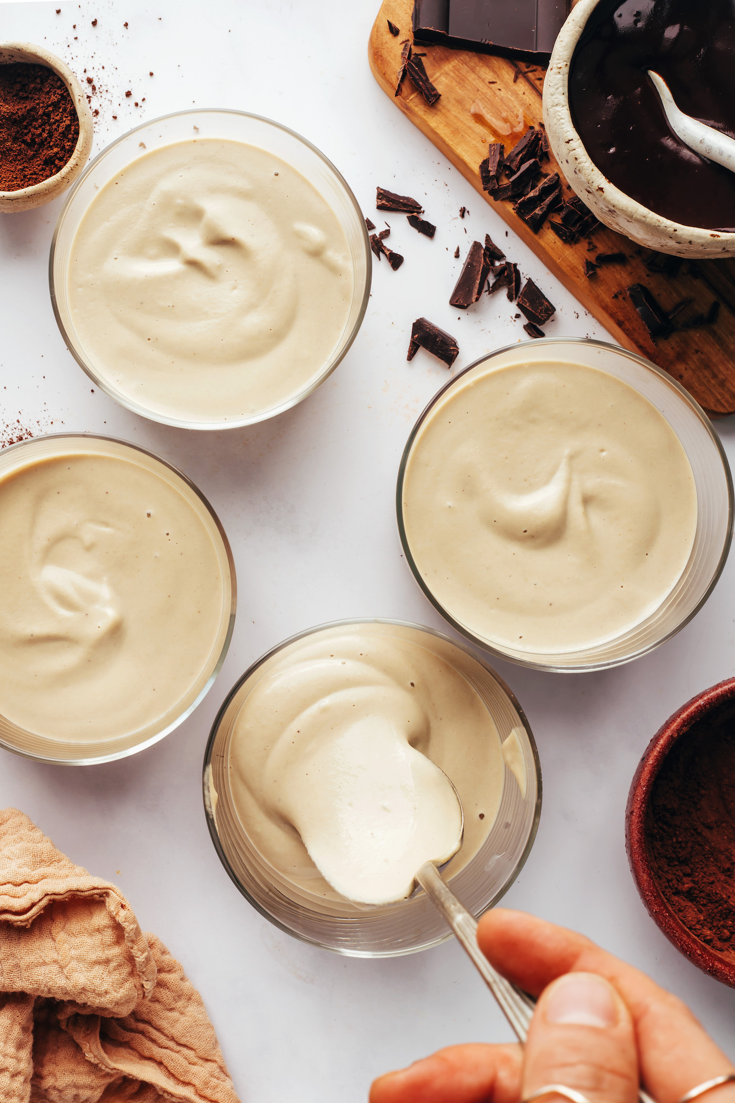 Using a spoon to divide a cashew coffee pudding between dessert glasses