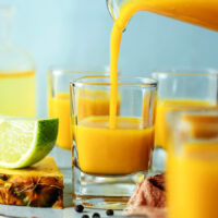 Pouring a fire cider wellness shot into a shot glass
