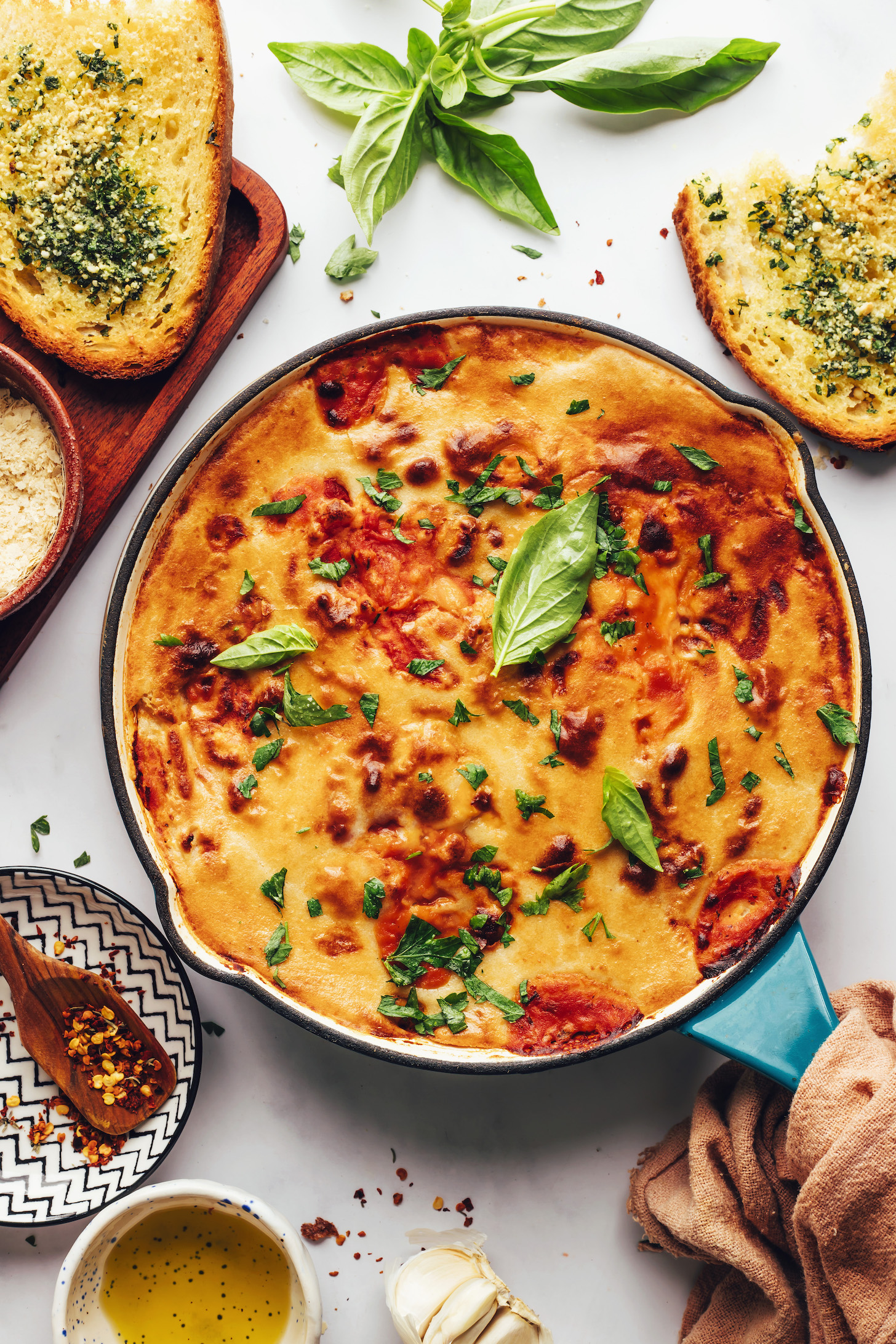 Fresh basil leaves sprinkled on a pan of vegan pizza beans