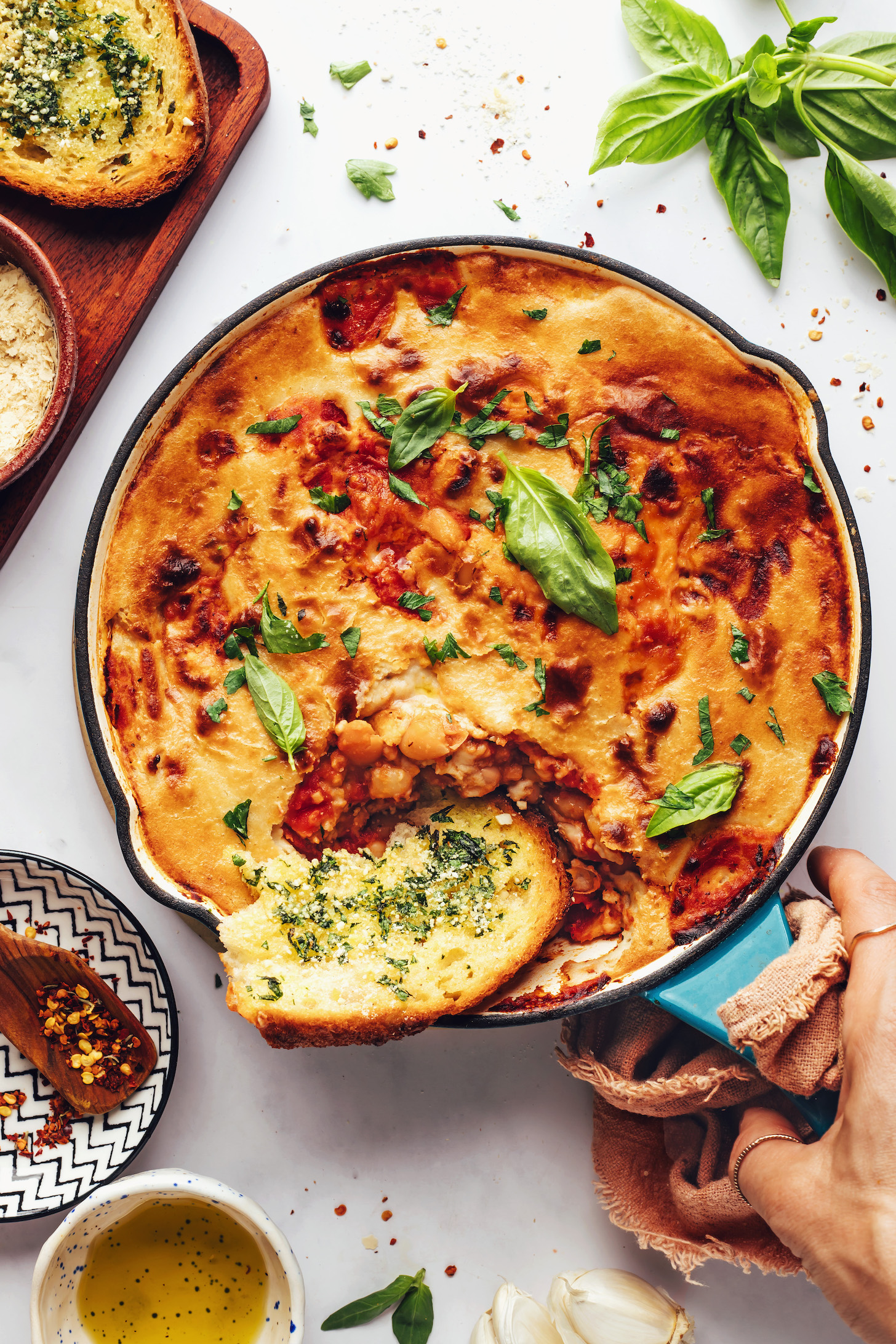 Slice of vegan garlic bread in a pan of pizza beans