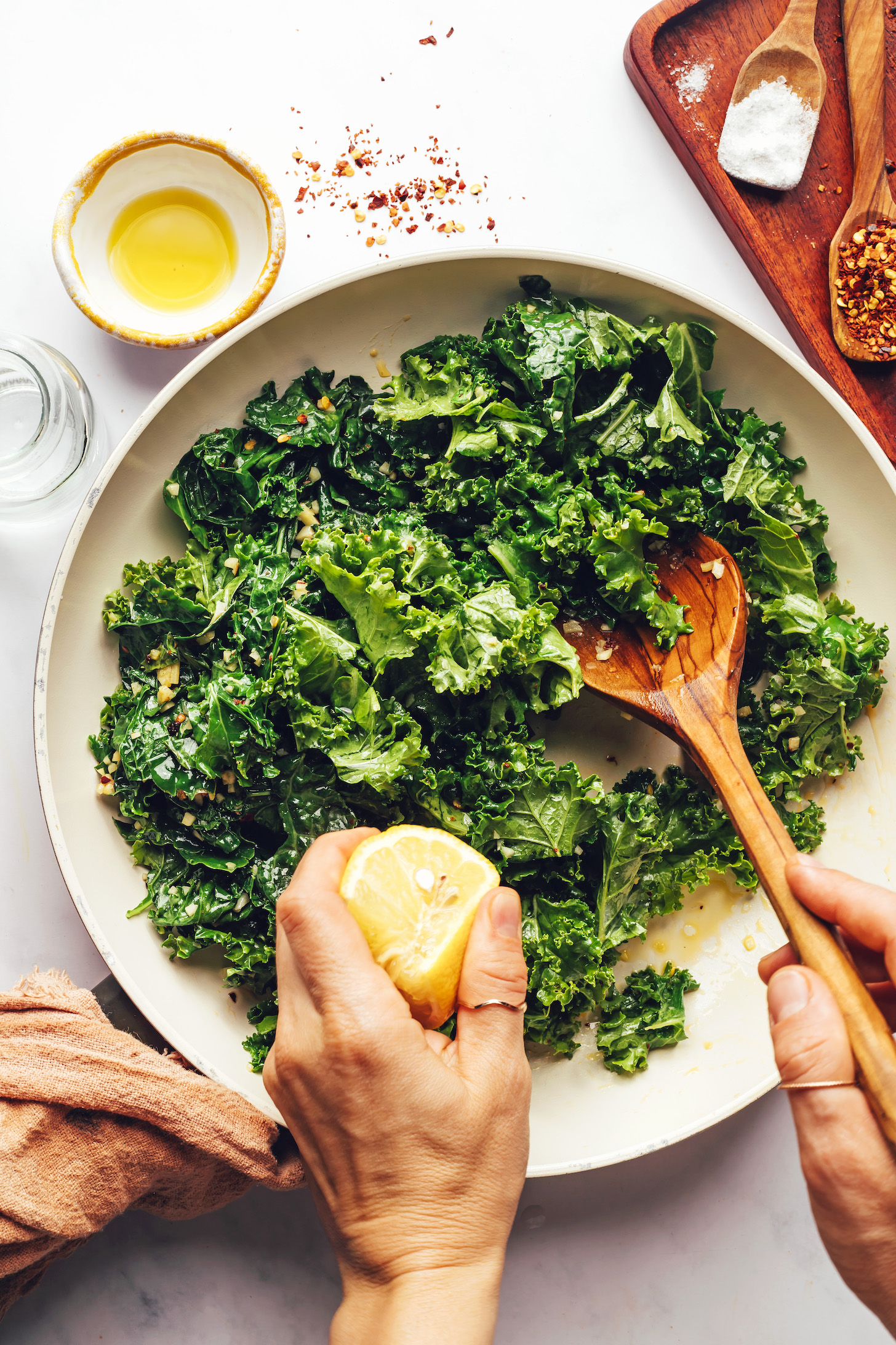 Squeezing lemon juice into a pan of chopped kale