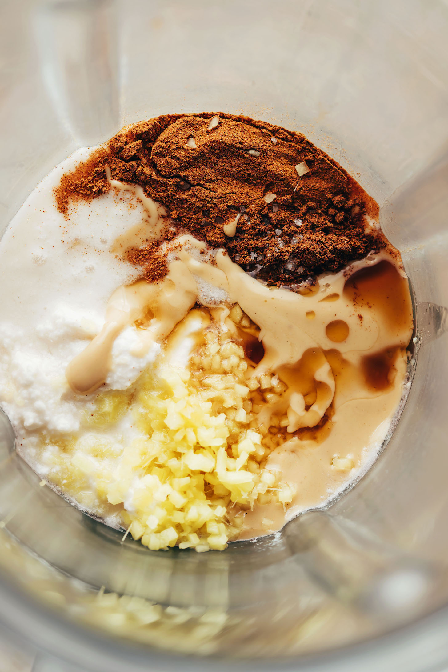 Fresh ginger, cashew butter, coconut milk, and spices in a blender