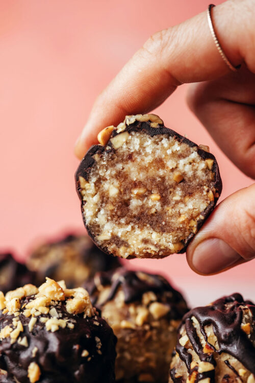 Holding up a snickers energy bite to show the inside