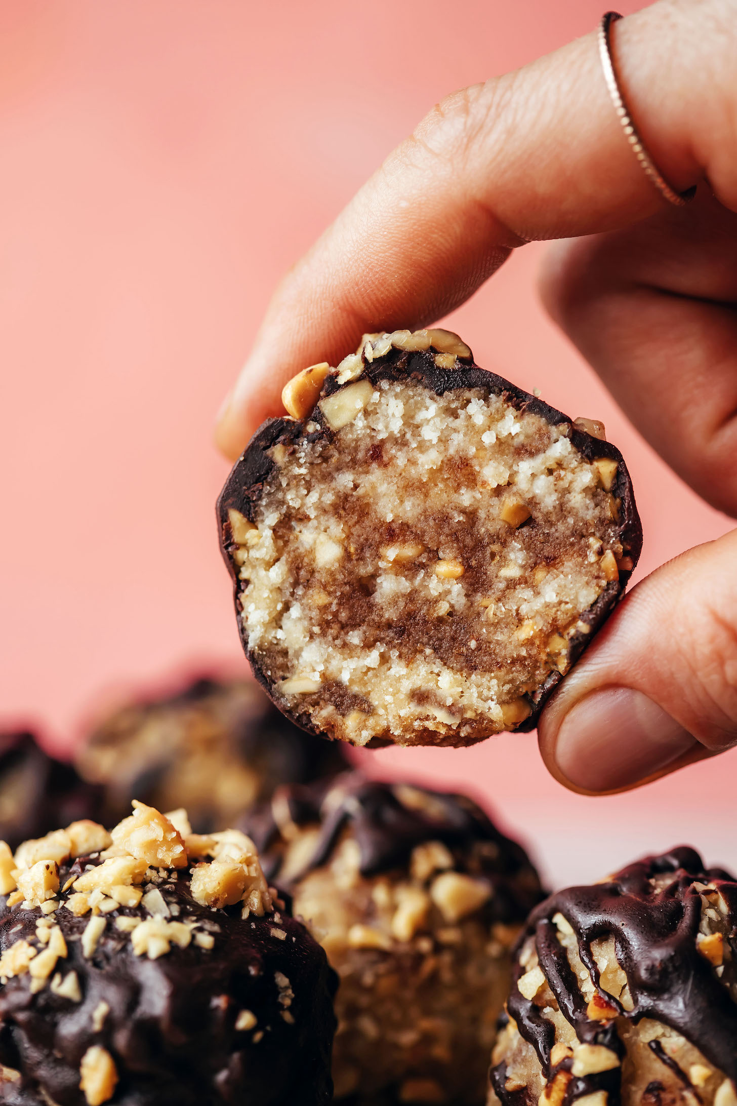 Holding a snickers energy bite between two fingers to show the inner texture