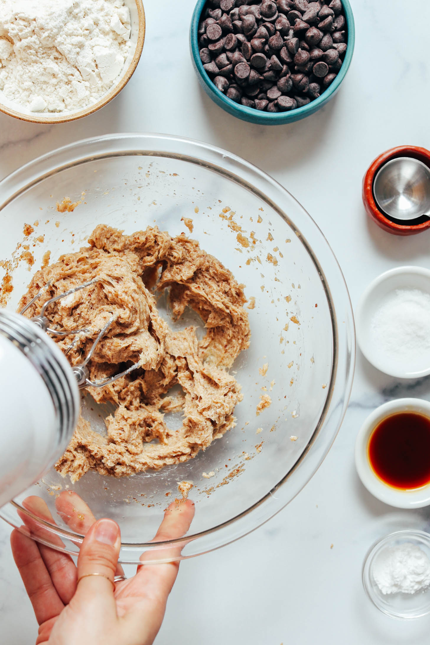 Using a hand mixer to whip together a flax egg, brown sugar, and softened vegan butter