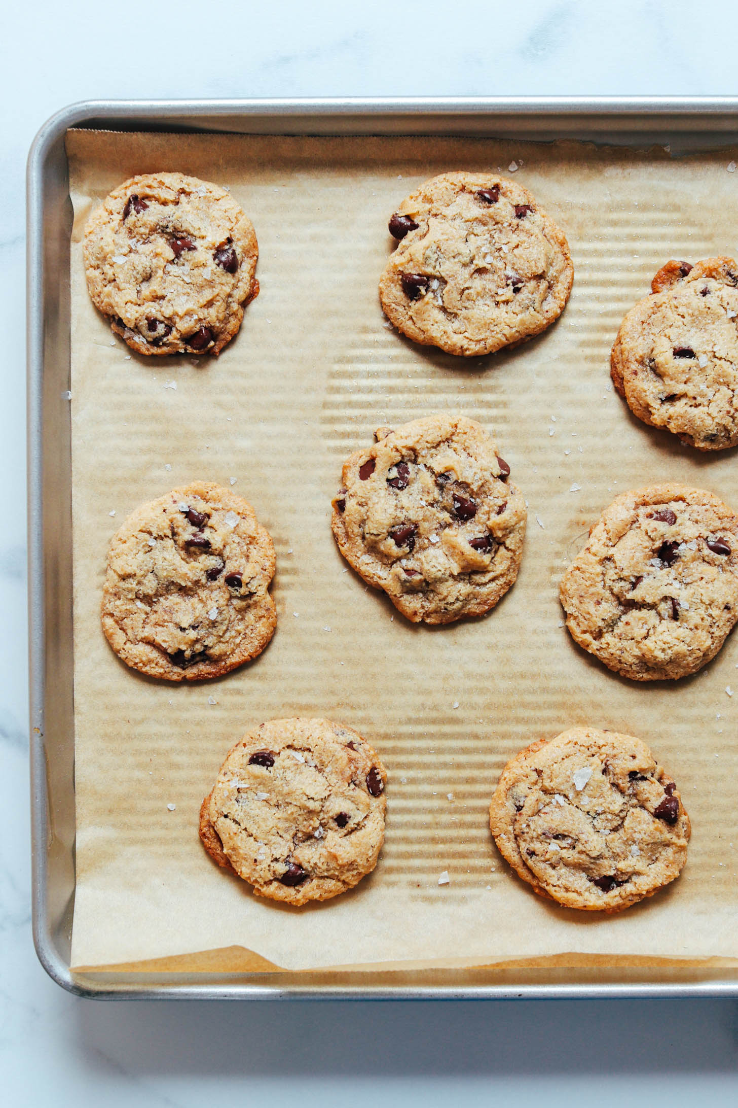 Baking sheet of chocolate chip cookies with crispy edges and soft centers