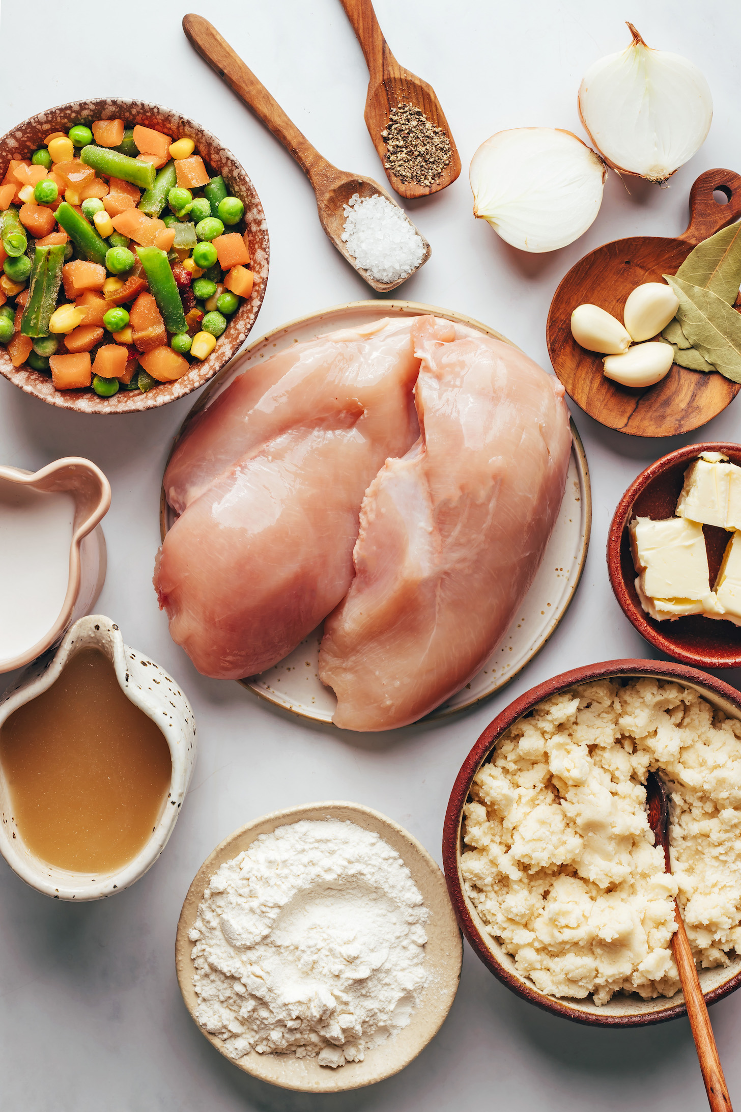Frozen mixed vegetables, coconut milk, chicken broth, gluten-free flour blend, gluten-free biscuit dough, dairy-free butter, garlic, bay leaves, onion, salt, and pepper