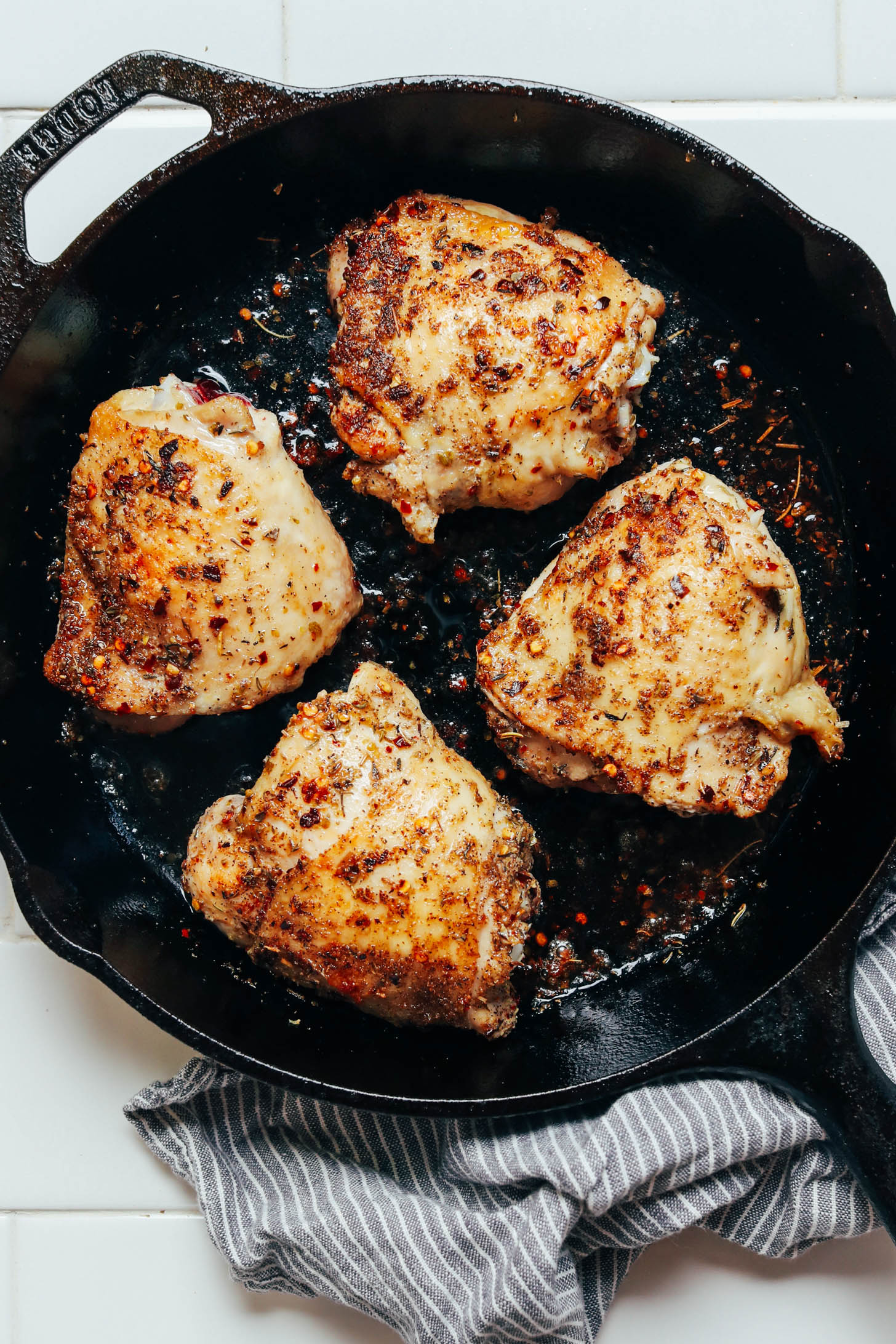 Cast iron skillet of herb roasted chicken thighs with crispy skin