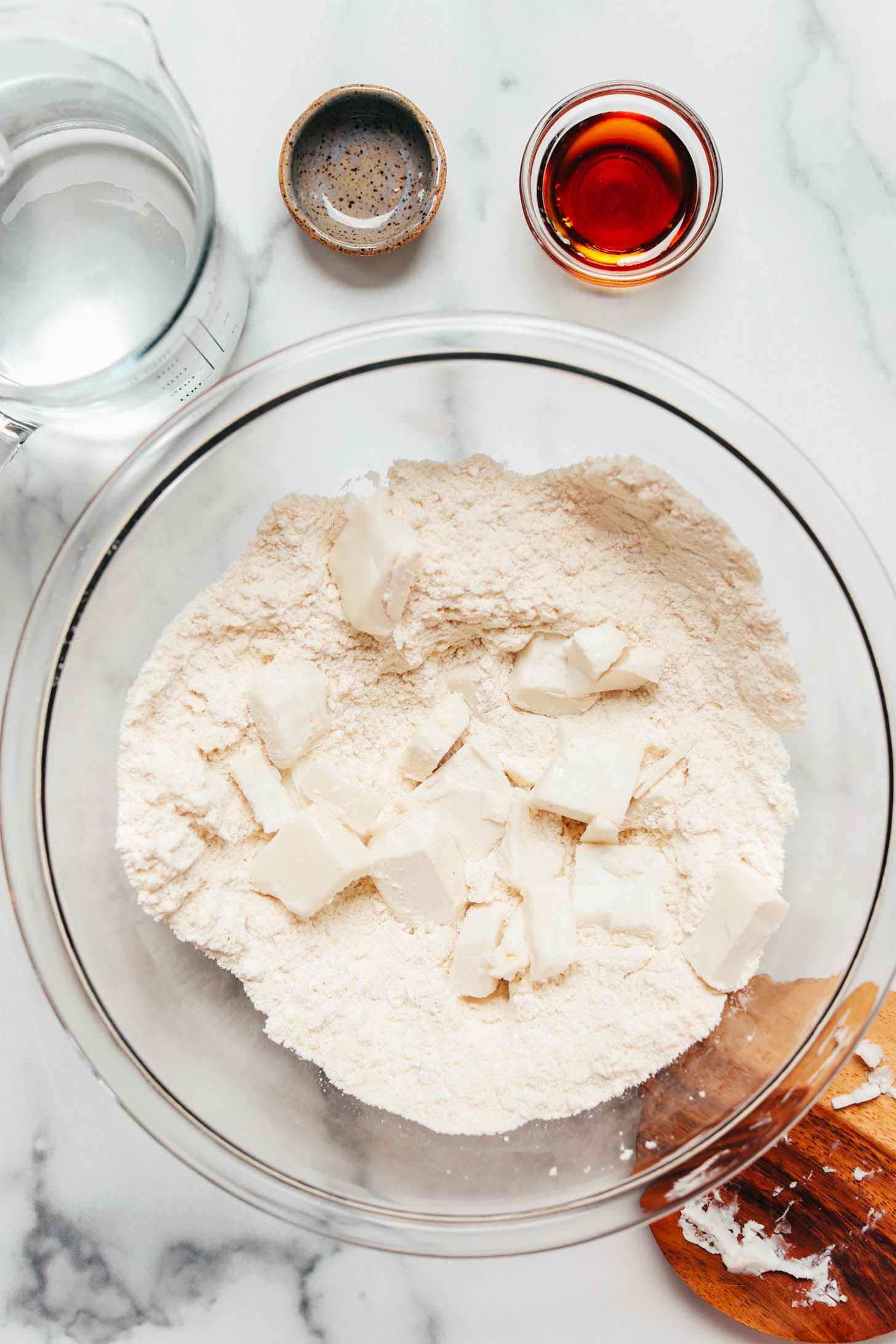 Cubed vegan butter in a bowl of dry ingredients