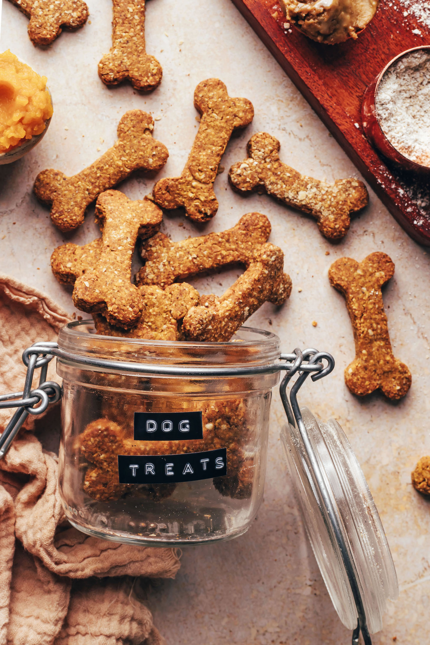 Peanut butter pumpkin dog treats spilling out of a glass jar