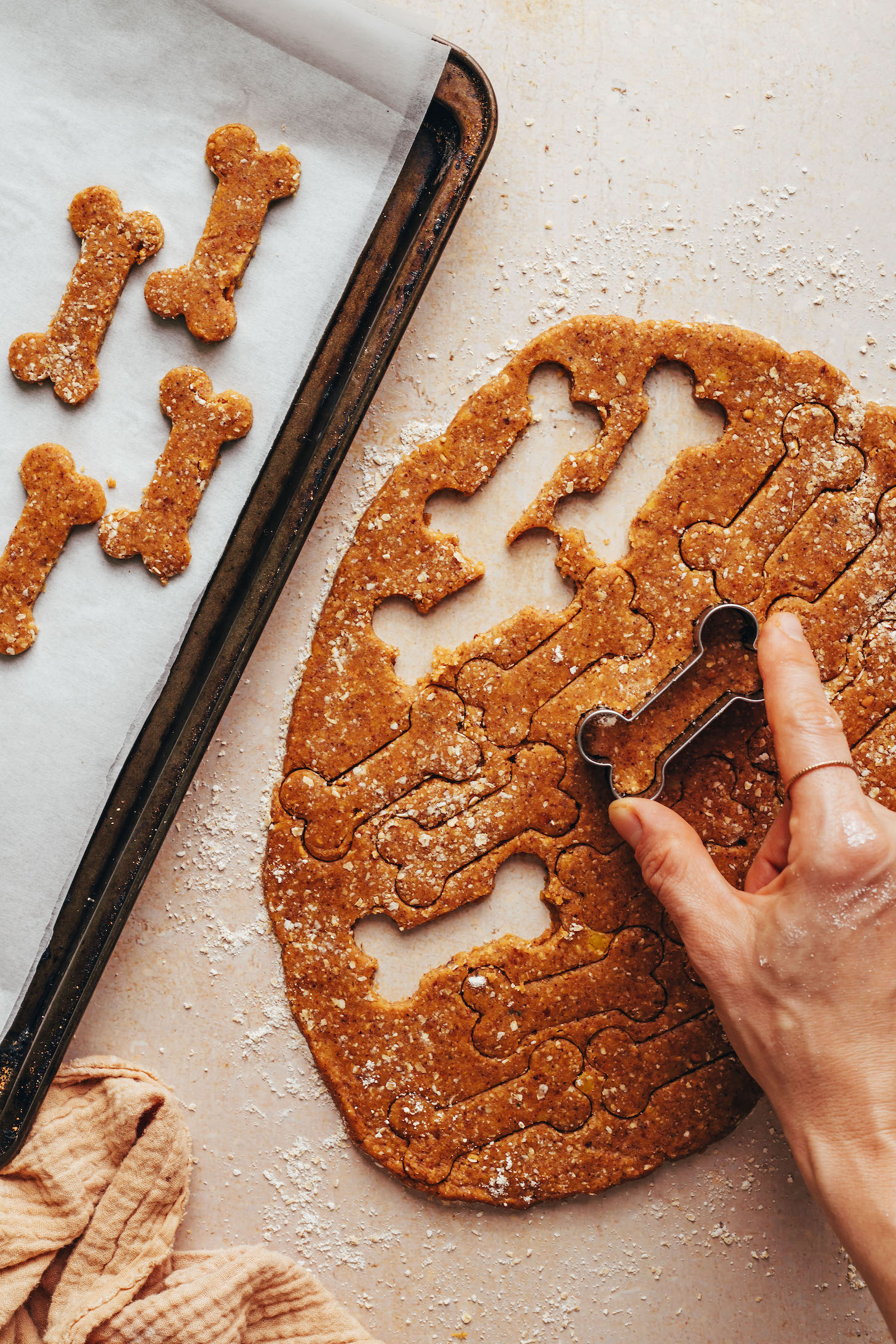 Using a small dog bone cookie cutter to cut out dough