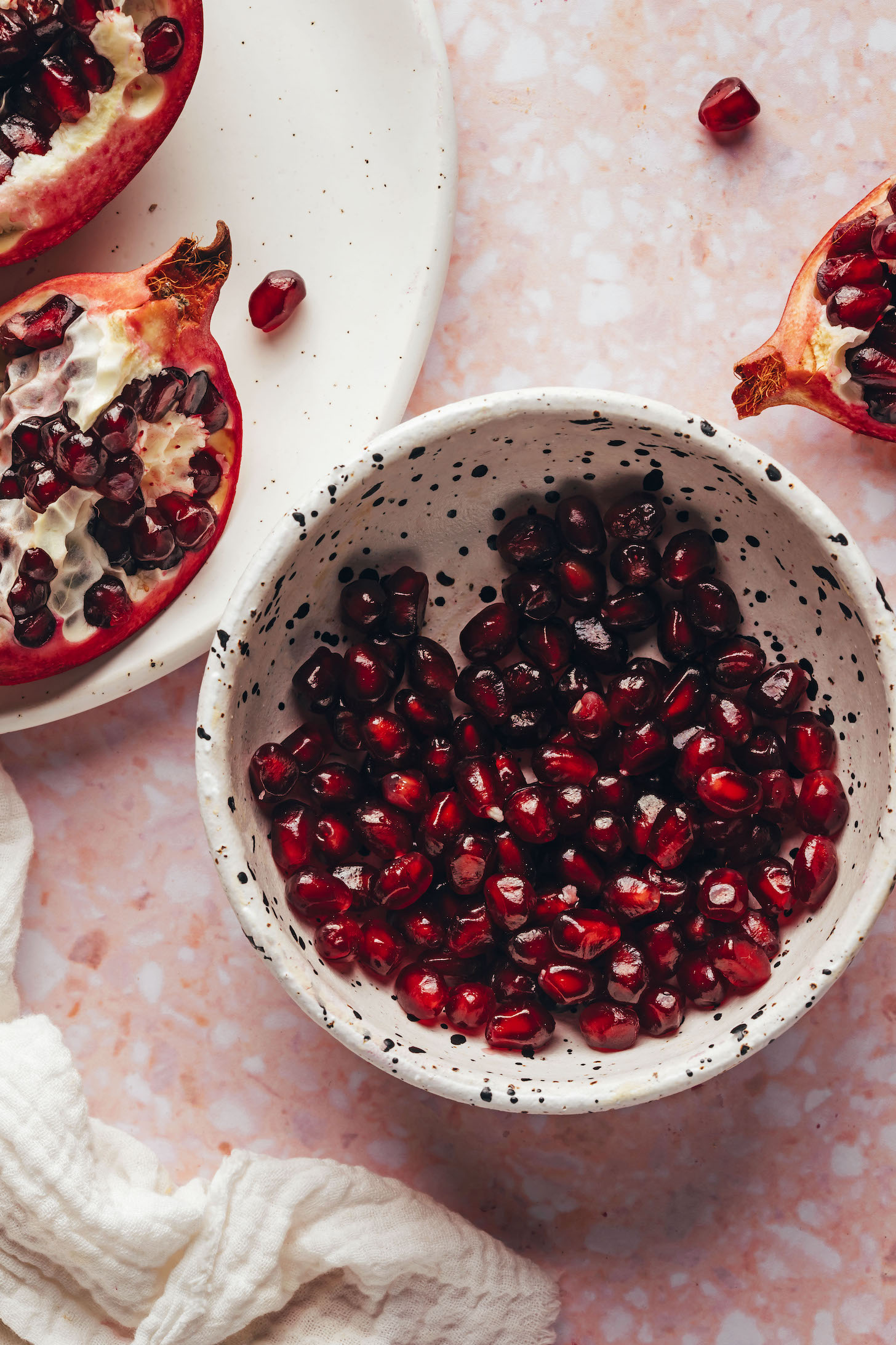 Opened pomegranate next to pomegranate for our tutorial on how to cut a pomegranate