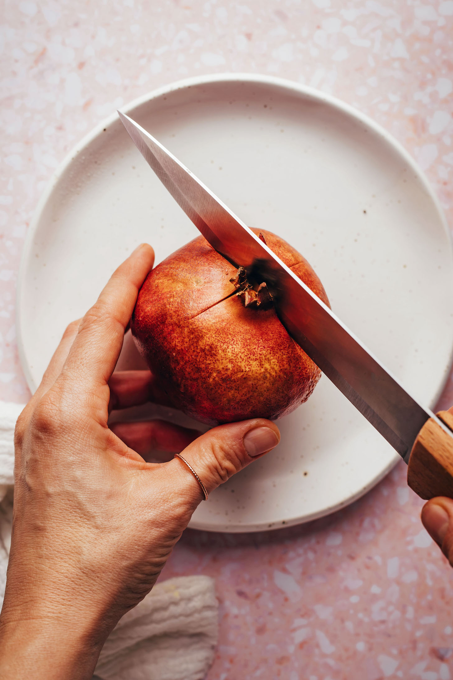 Cutting a cross in the top of a pomegranate