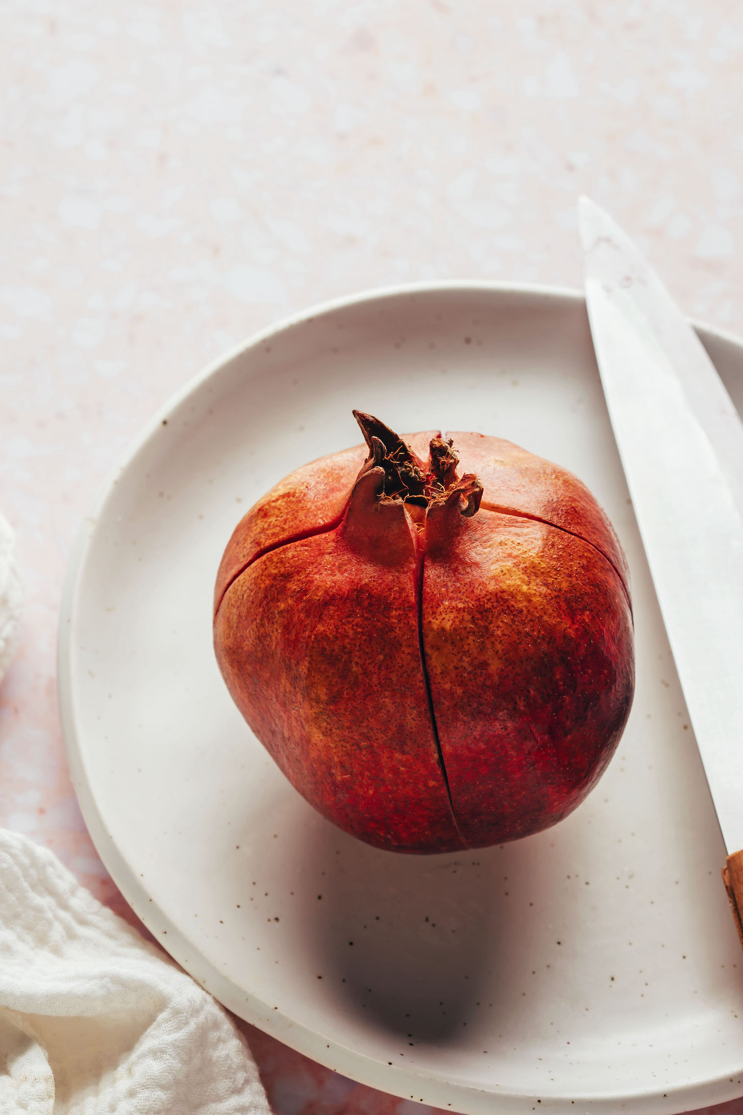 Scoring a pomegranate into quarters to show the best way to cut a pomegranate