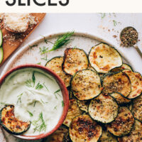 Bowl of vegan ranch next to baked zucchini slices