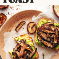 Two slices of mushroom avocado toast on a plate with text above it that says 1 pan and 10 minutes