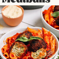 Bowl of penne arrabbiata topped with pesto turkey meatballs