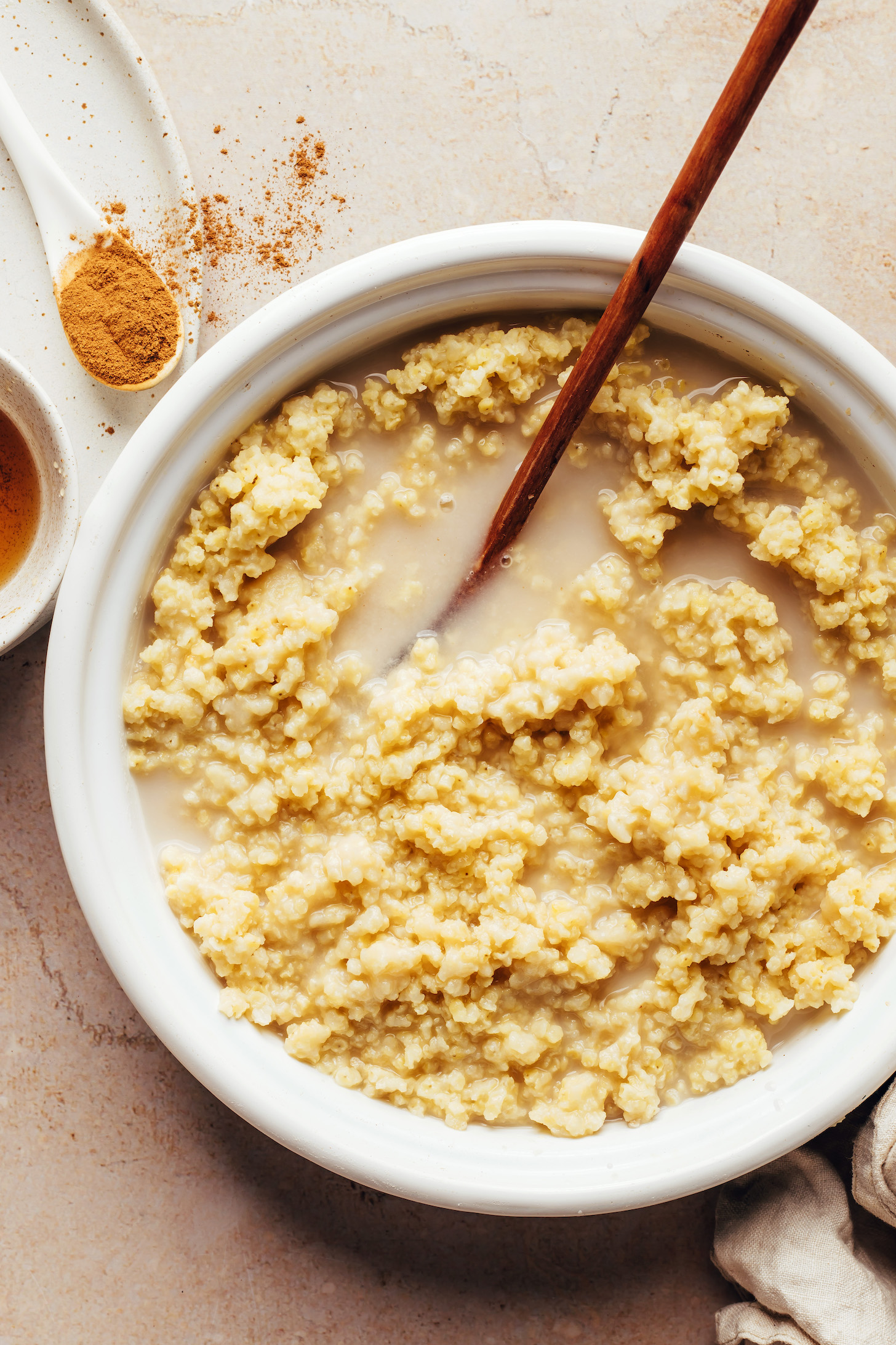 Spices next to a saucepan of cooked millet