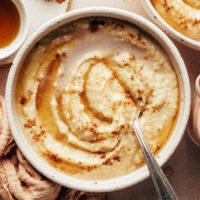 Bowl of creamy millet porridge swirled with maple syrup