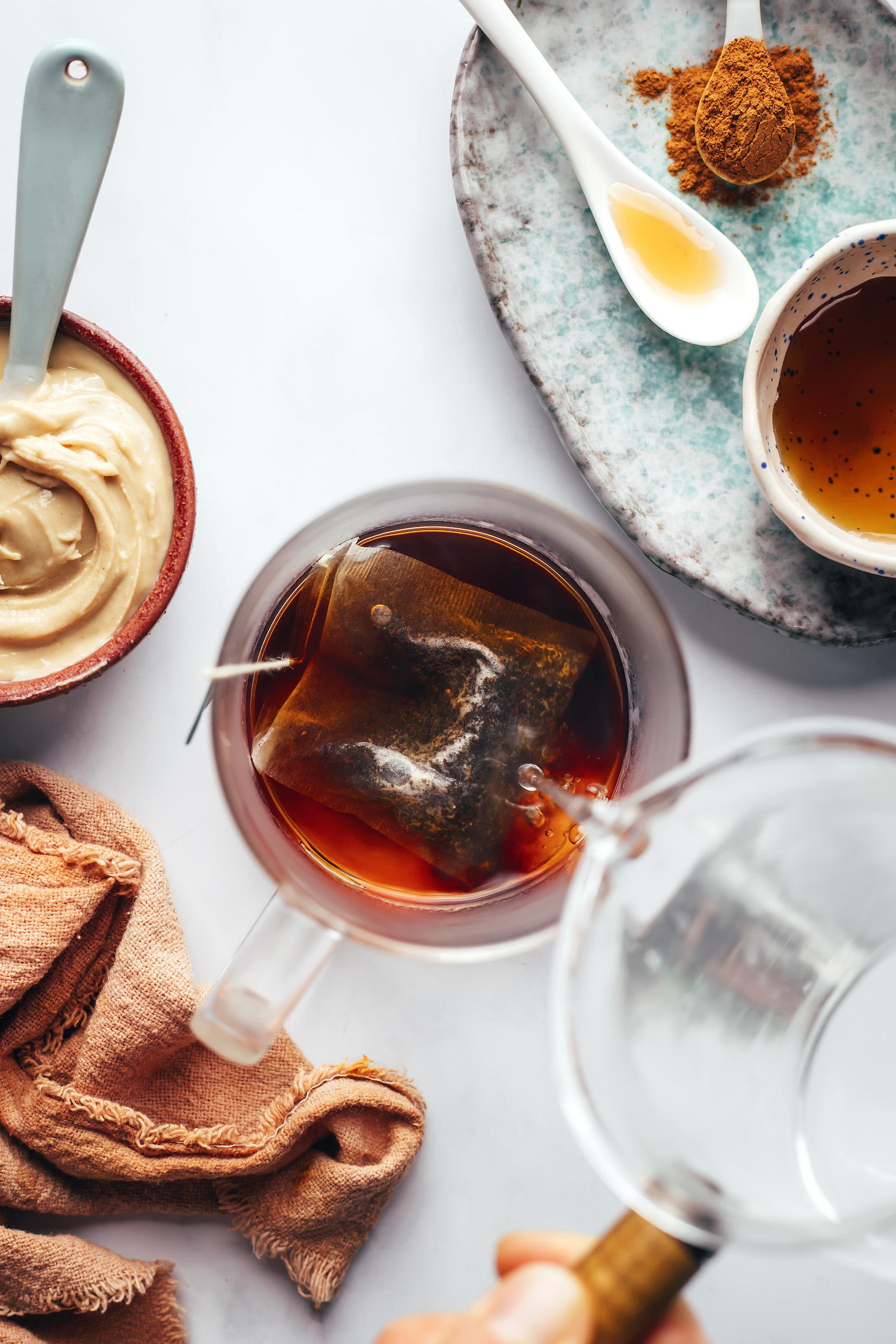 Adding hot water over a tea bag to brew dandelion root tea