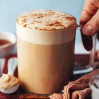 Holding the handle of a mug filled with our dandelion tea latte recipe