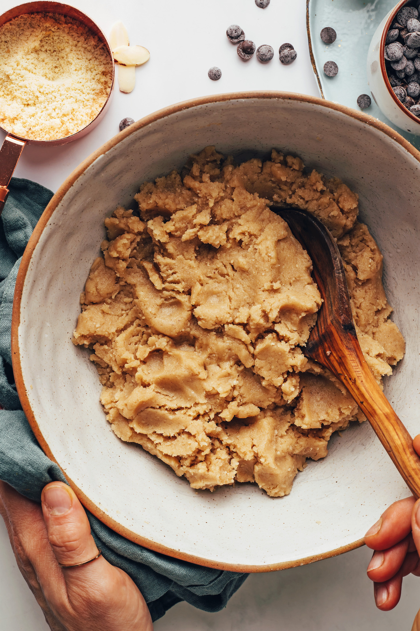 Almond flour and chocolate chips next to a bowl of almond biscotti dough