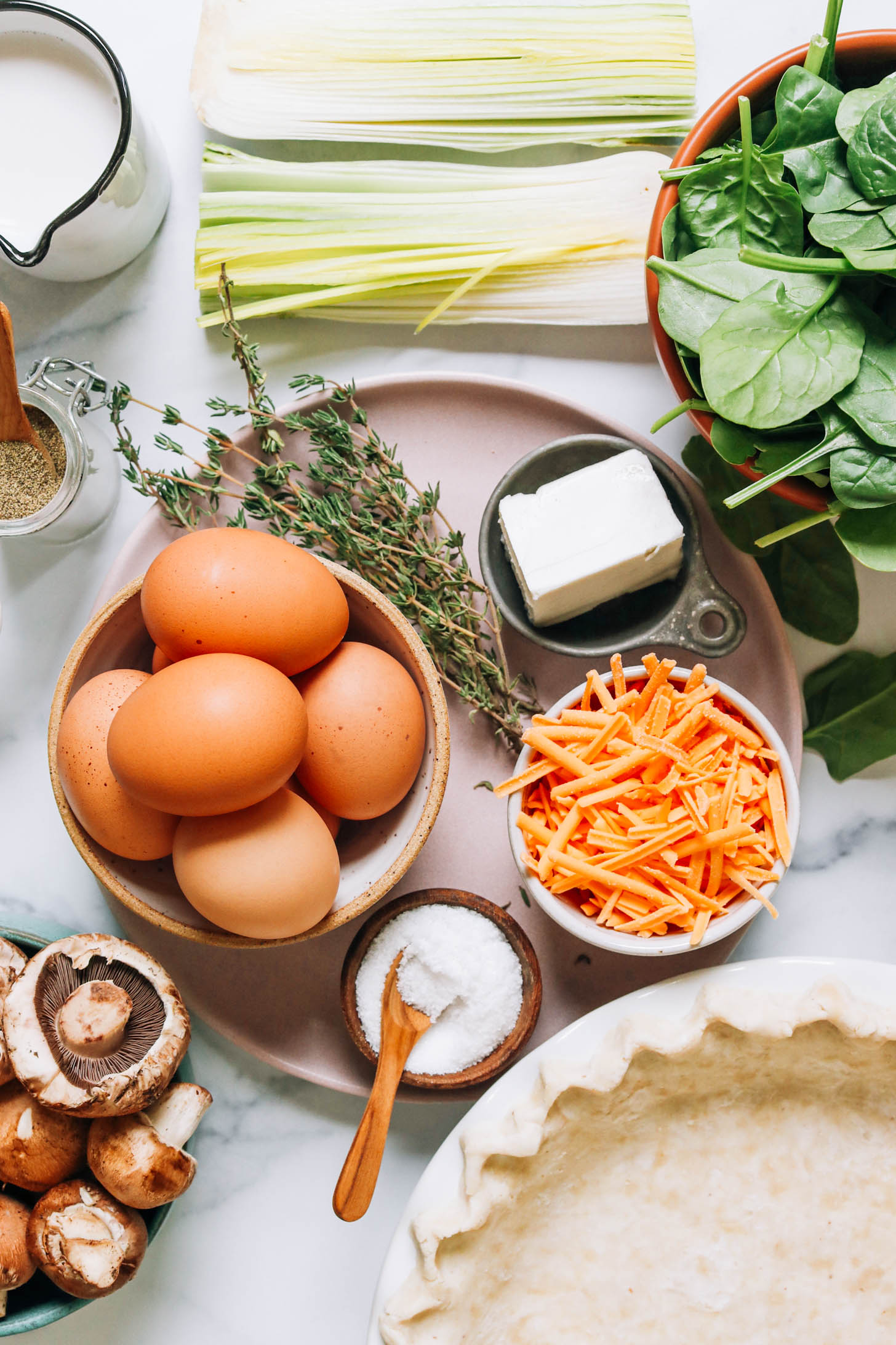 Dairy-free milk, dairy-free butter, leek, spinach, dairy-free cheese, pie crust, salt, mushrooms, eggs, thyme, and black pepper