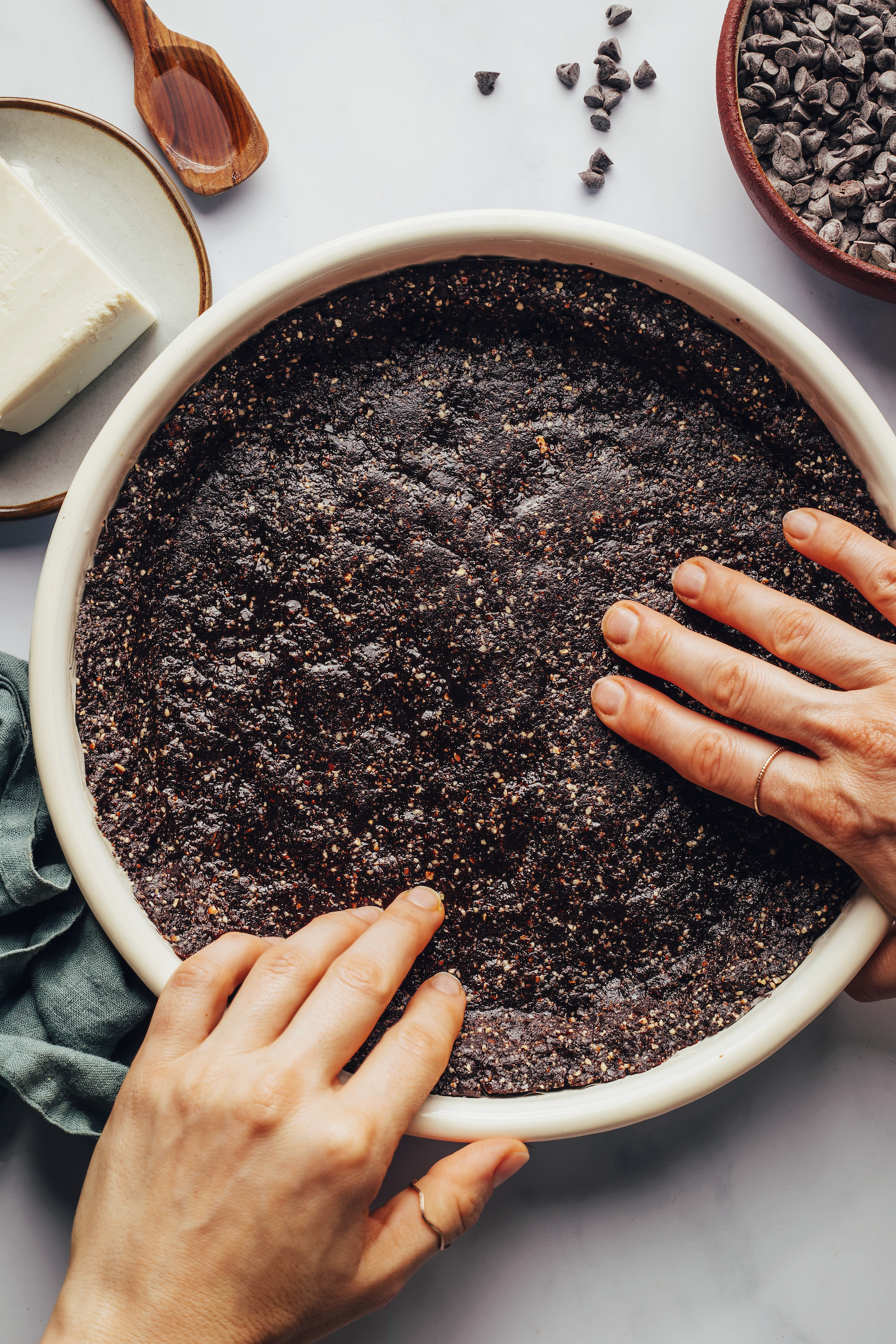 Pressing a chocolate-date-pecan crust into a pie pan