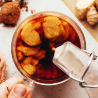 Overhead shot of pouring pumpkin spice coffee creamer into a glass of coffee