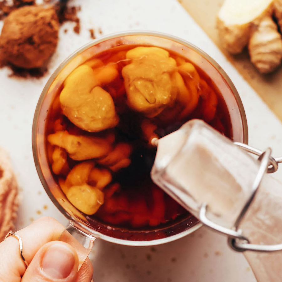 Overhead shot of pouring pumpkin spice coffee creamer into a glass of coffee