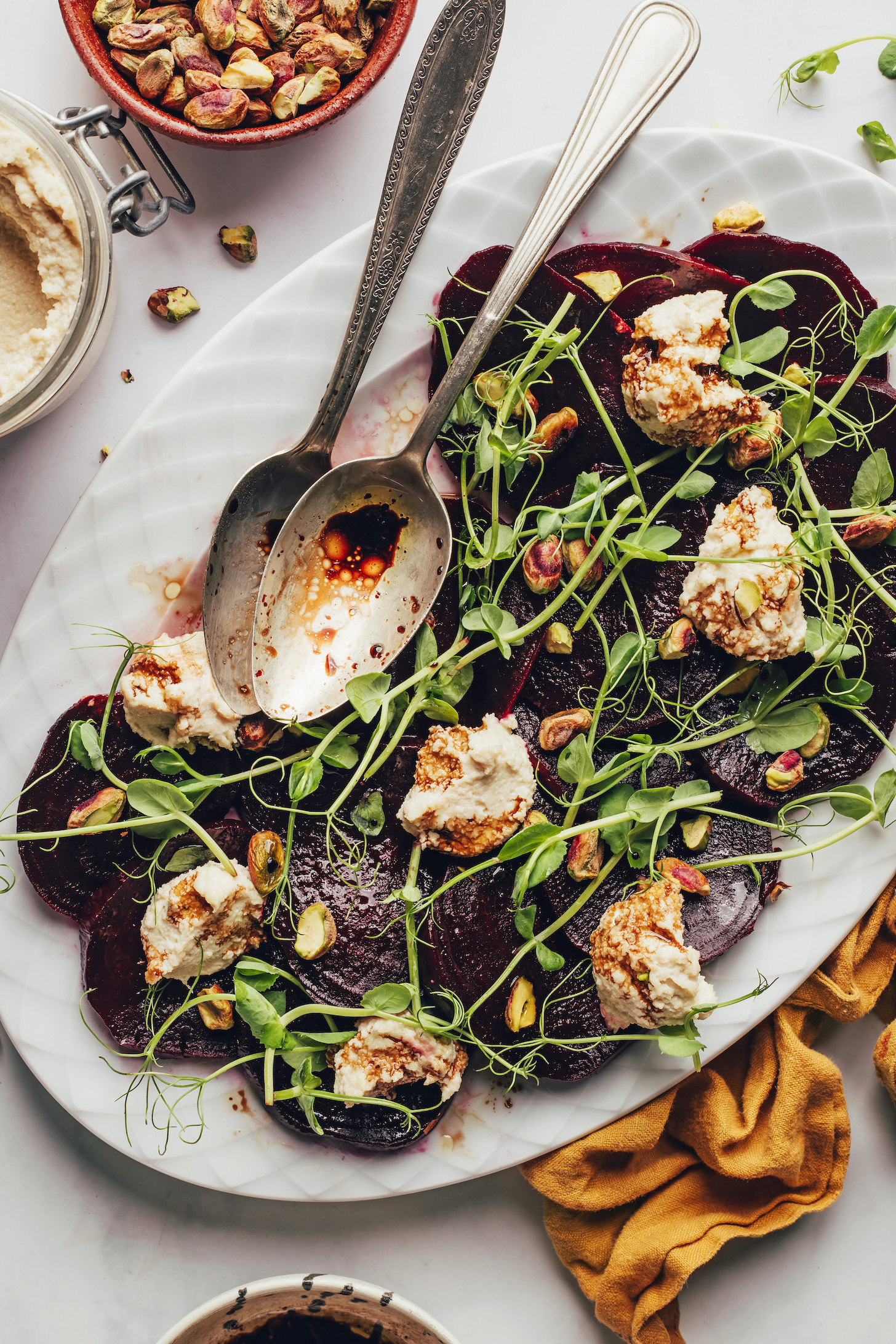 Serving spoons resting on a platter of our vegan roasted beet salad recipe