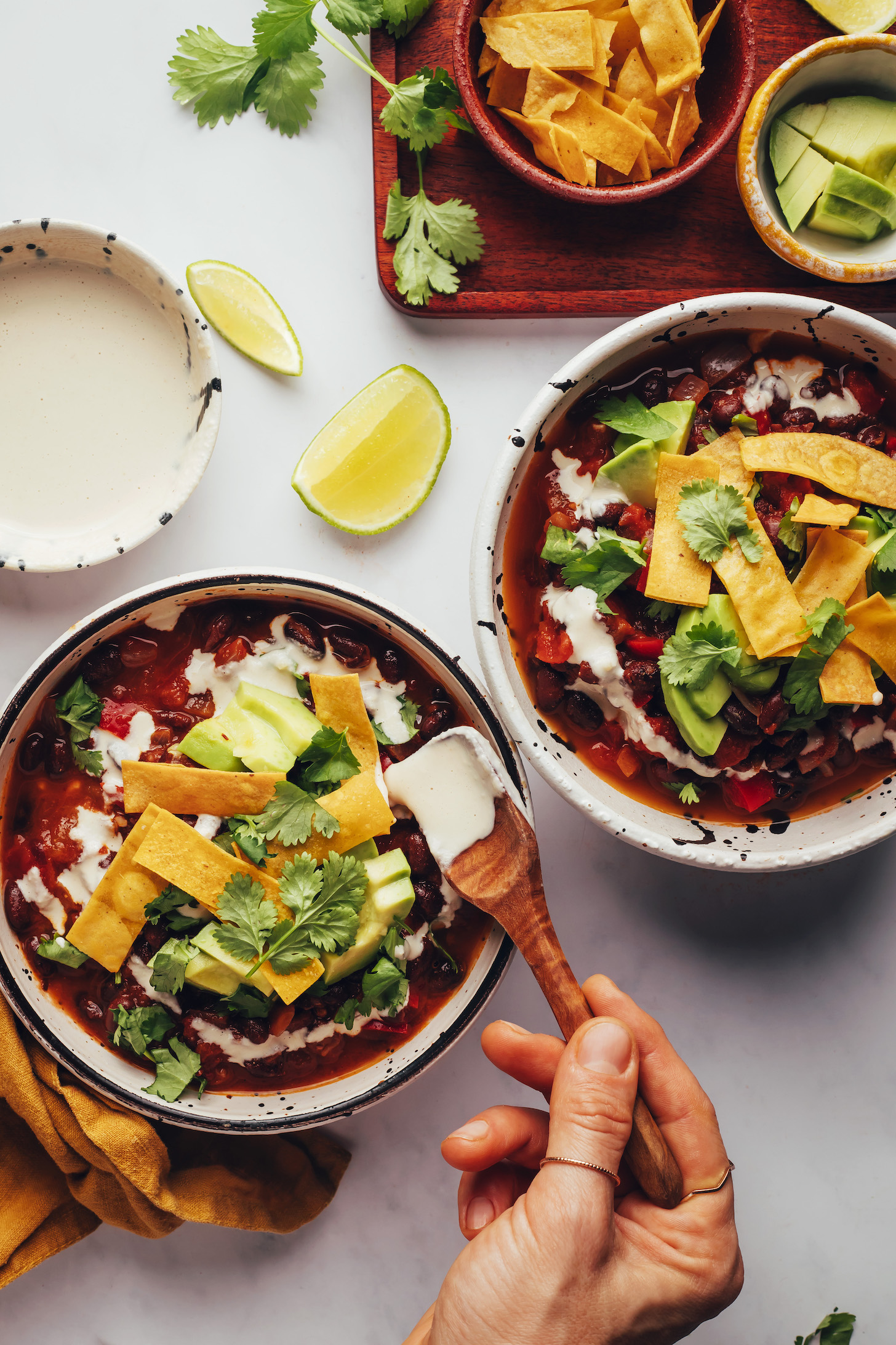 Adding cashew cream to a bowl of chipotle black bean chili