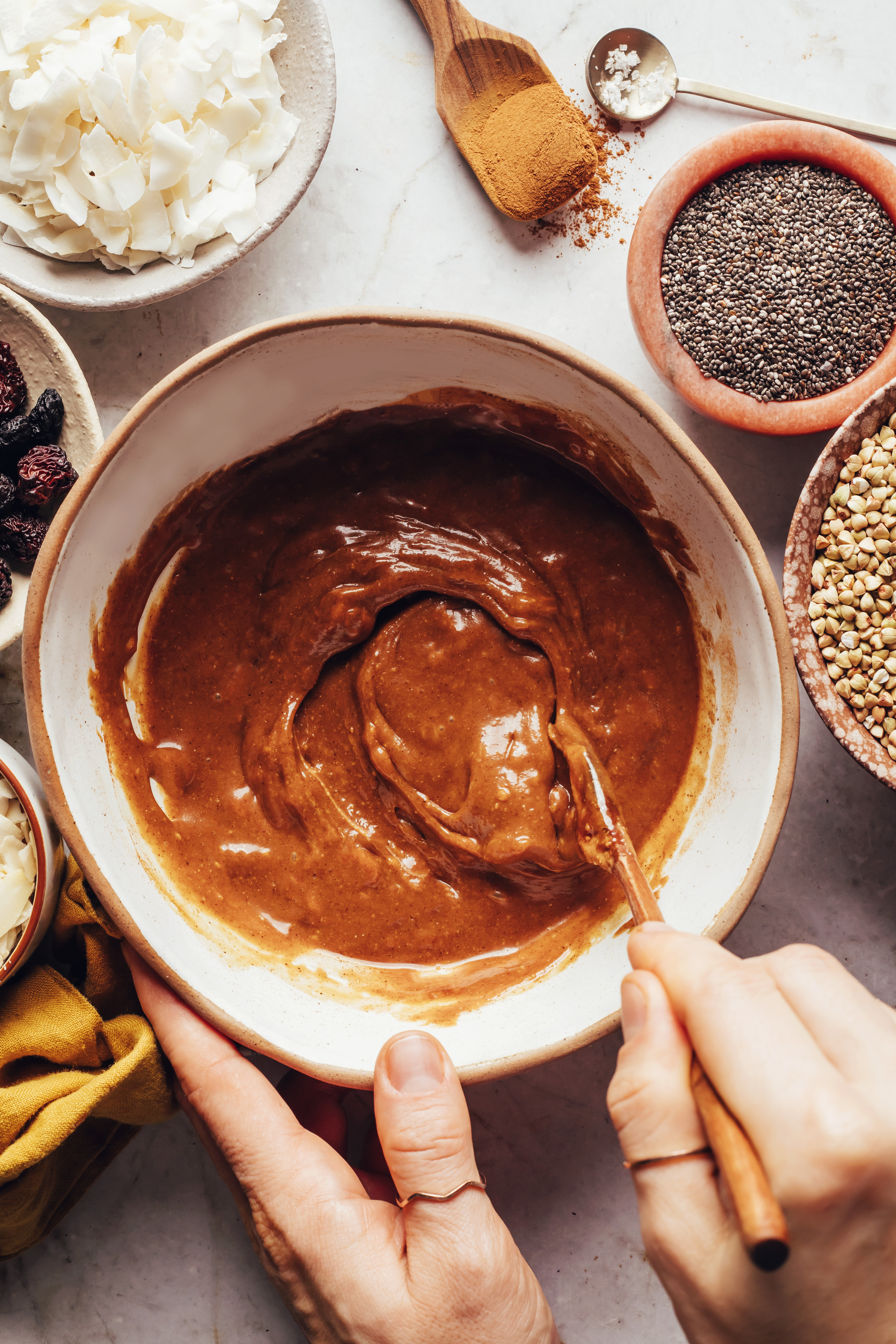 Stirring together maple syrup and almond butter in a bowl