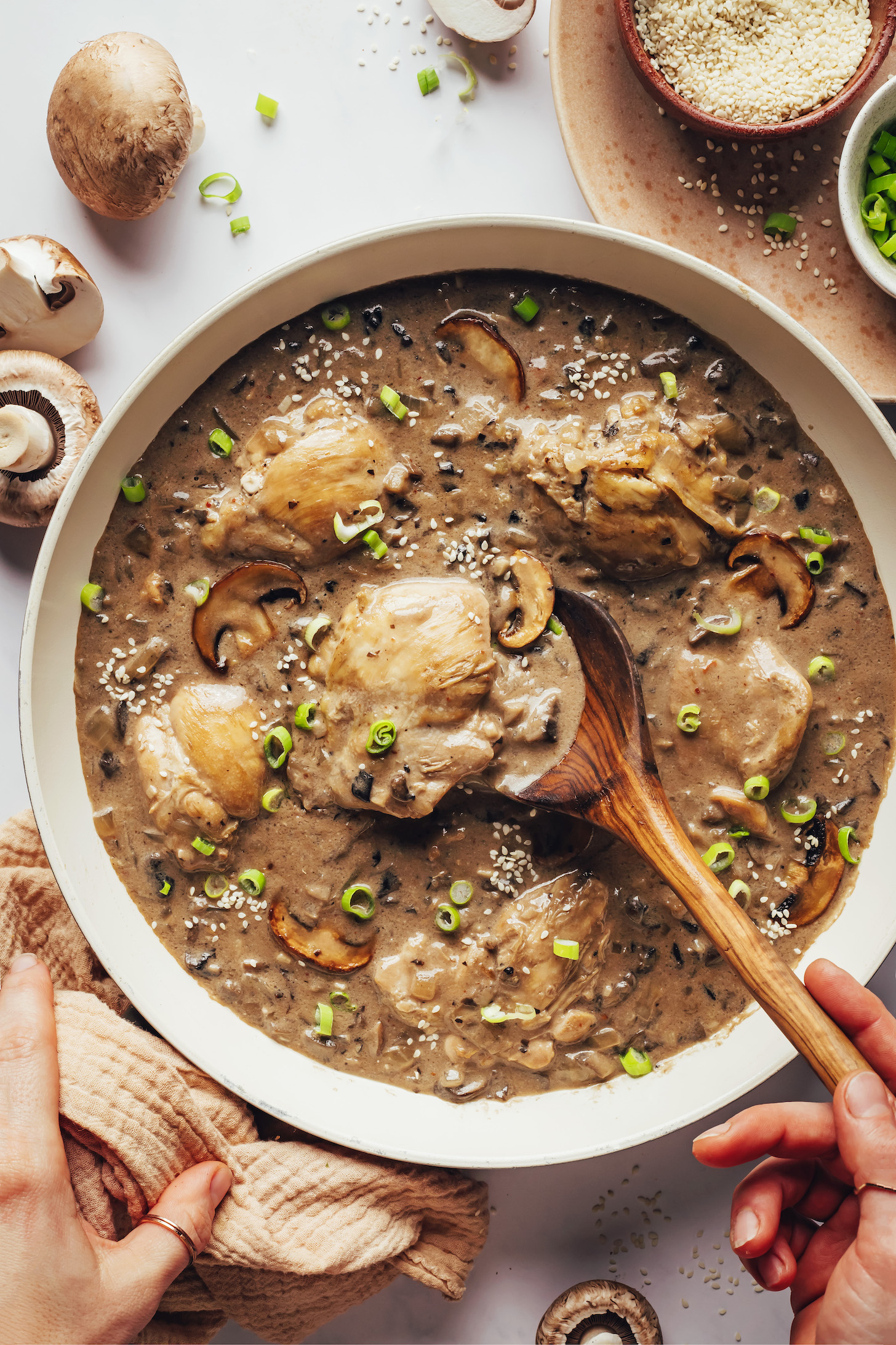 Using a wooden spoon to stir a pot of Samoan mushroom chicken