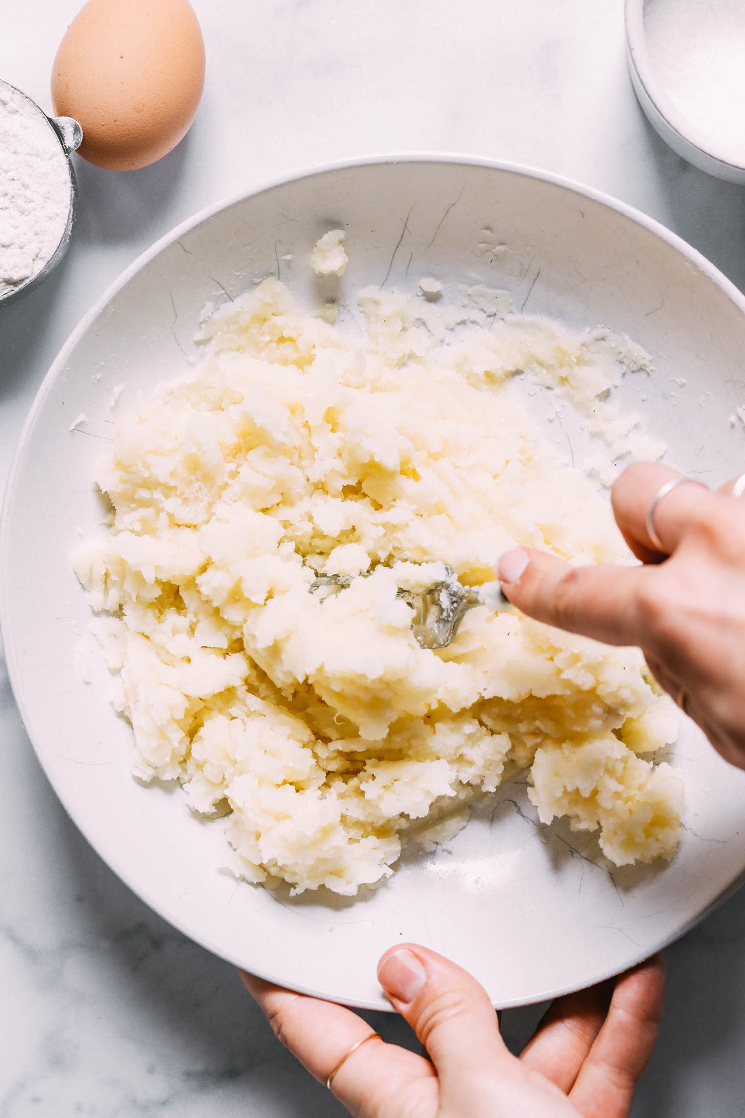 Mashing baked potatoes with a fork