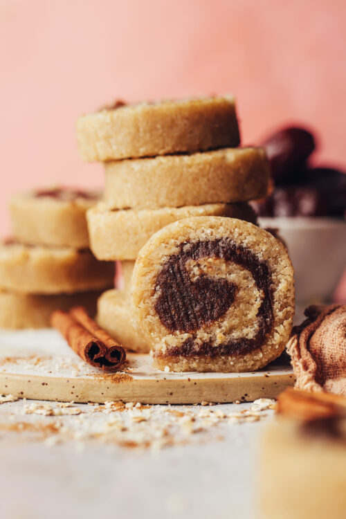 Cinnamon stick next to a no-bake cinnamon roll and a stack of more of them