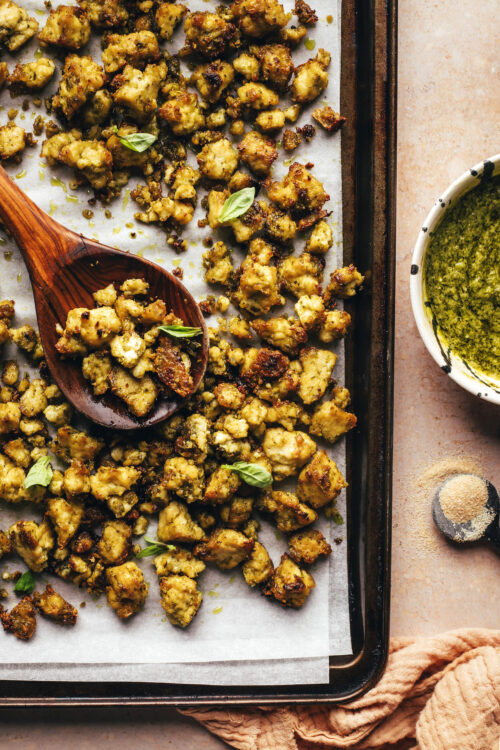 Parchment-lined baking sheet of crispy pesto tofu