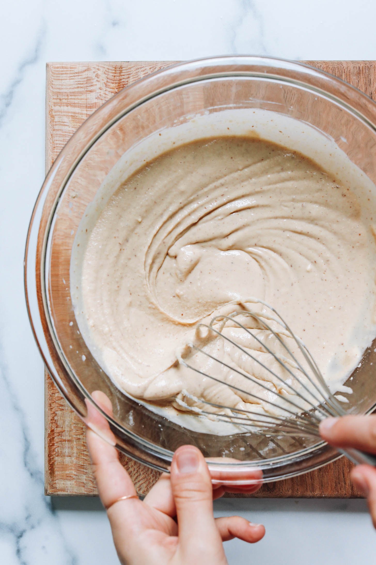 Whisking pancake batter in a glass mixing bowl