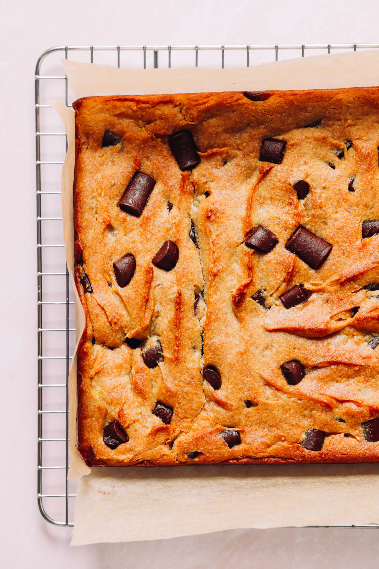 Freshly baked batch of sweet potato blondies on a cooling rack