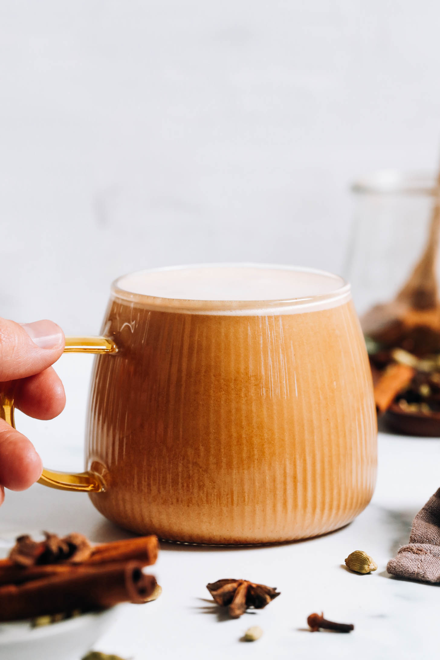 Holding the handle on a mug of a vegan dirty chai latte