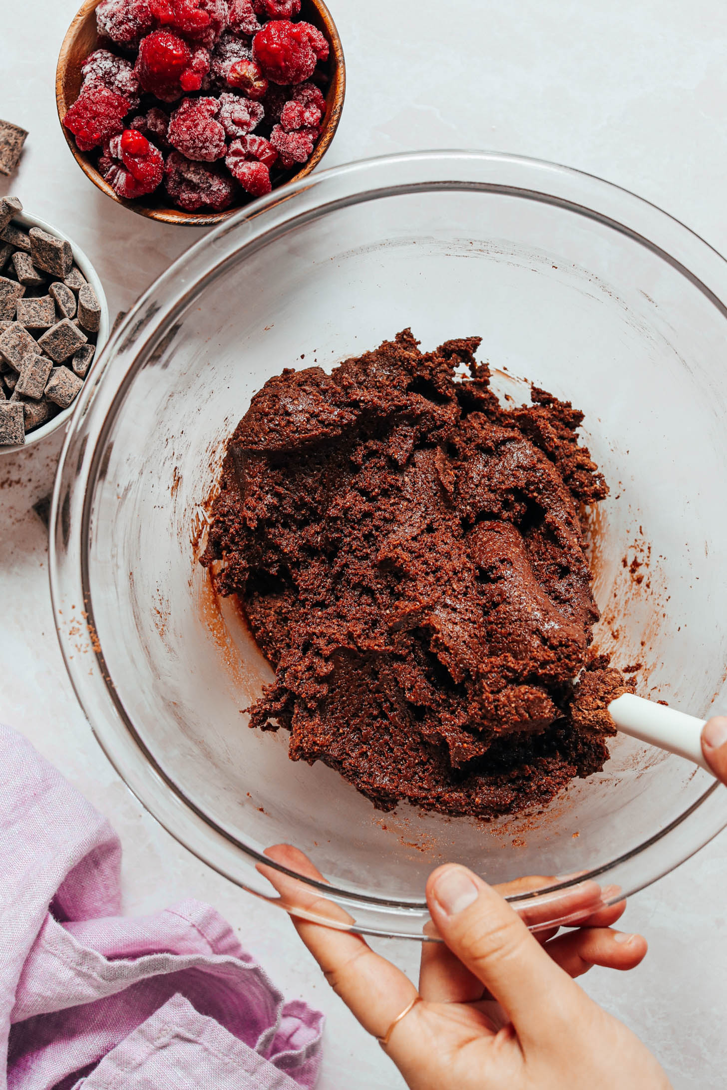 Using a spatula to mix together the wet and dry ingredients