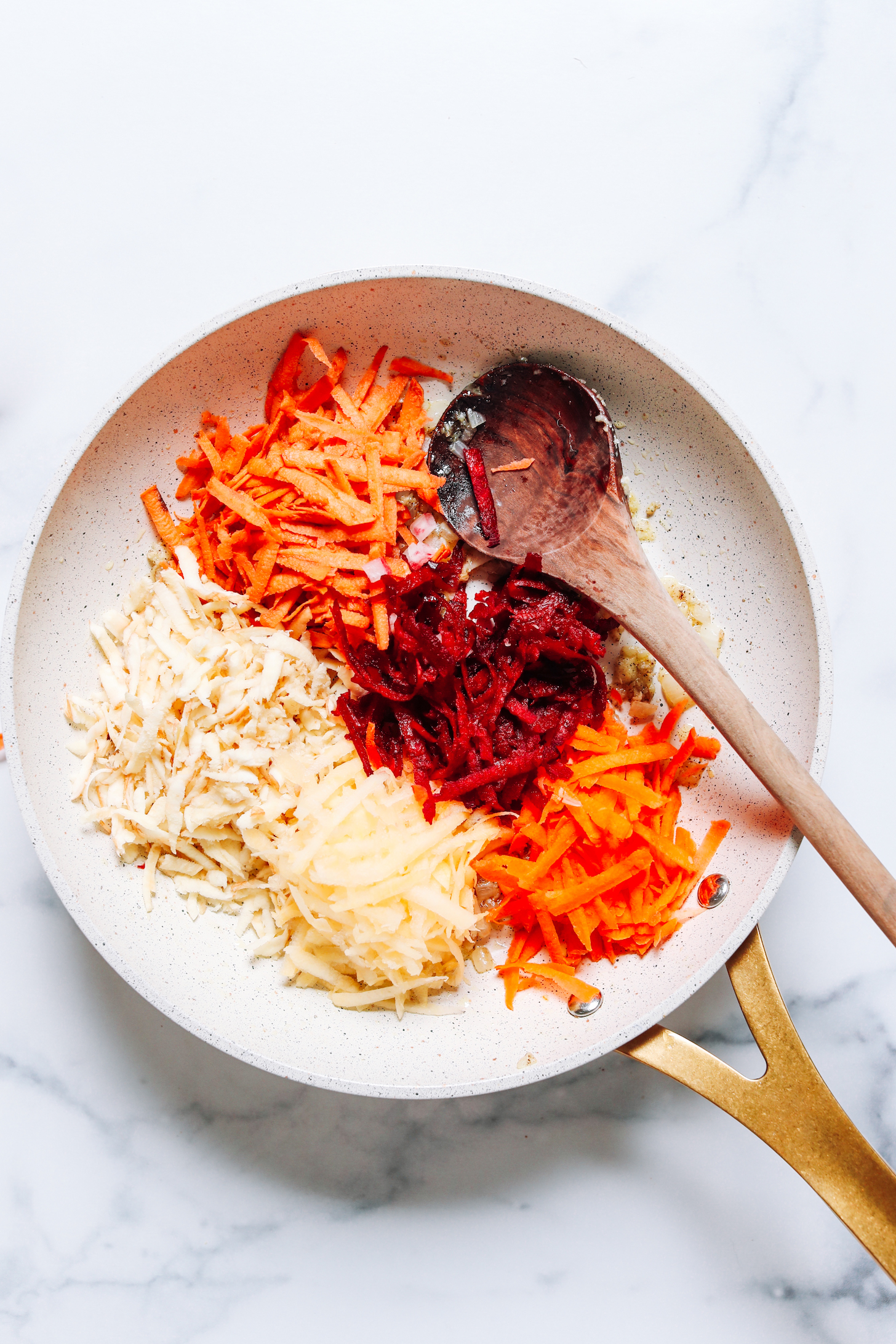 Sautéing shredded root vegetables in a skillet