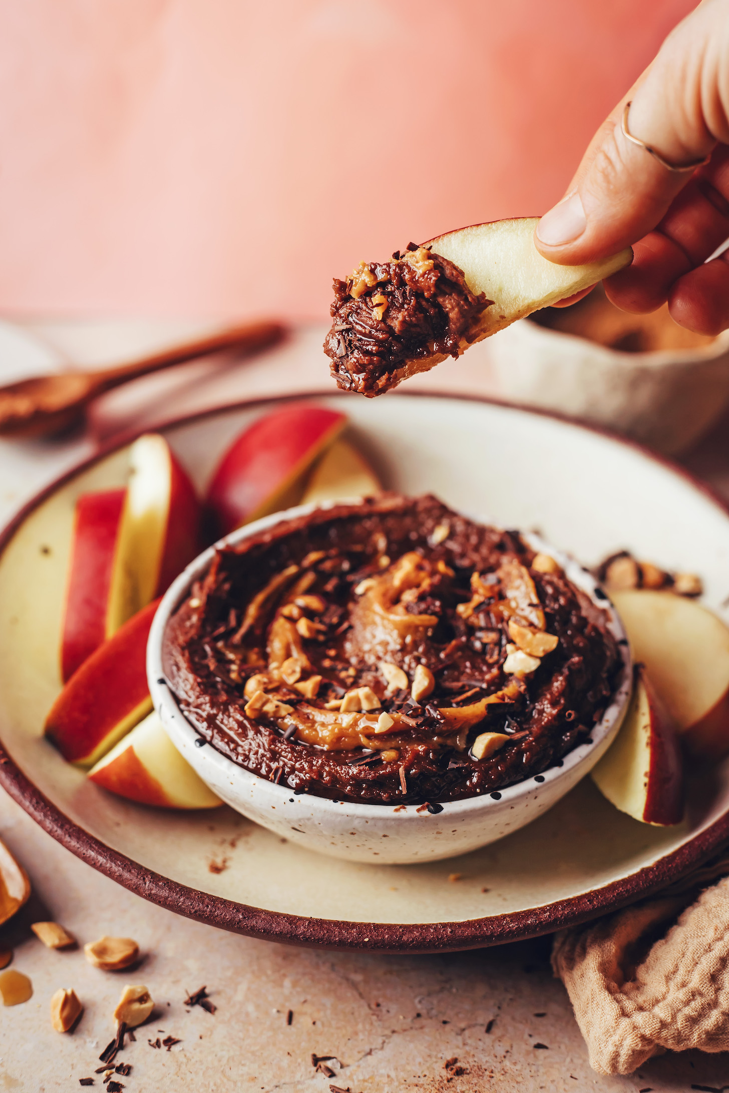Holding up a slice of apple with vegan chocolate hummus on one side