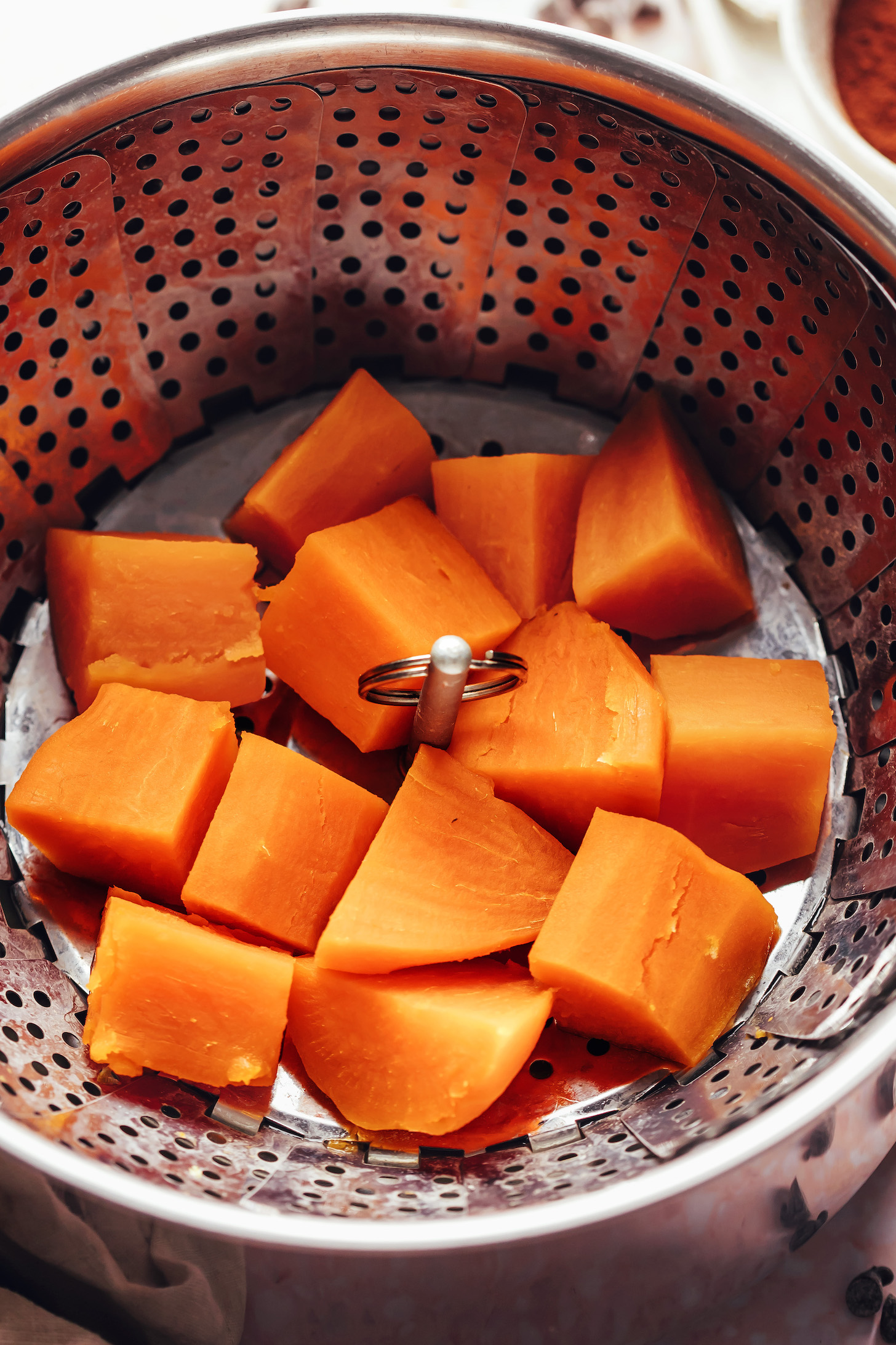 Cubed sweet potatoes in a steamer basket