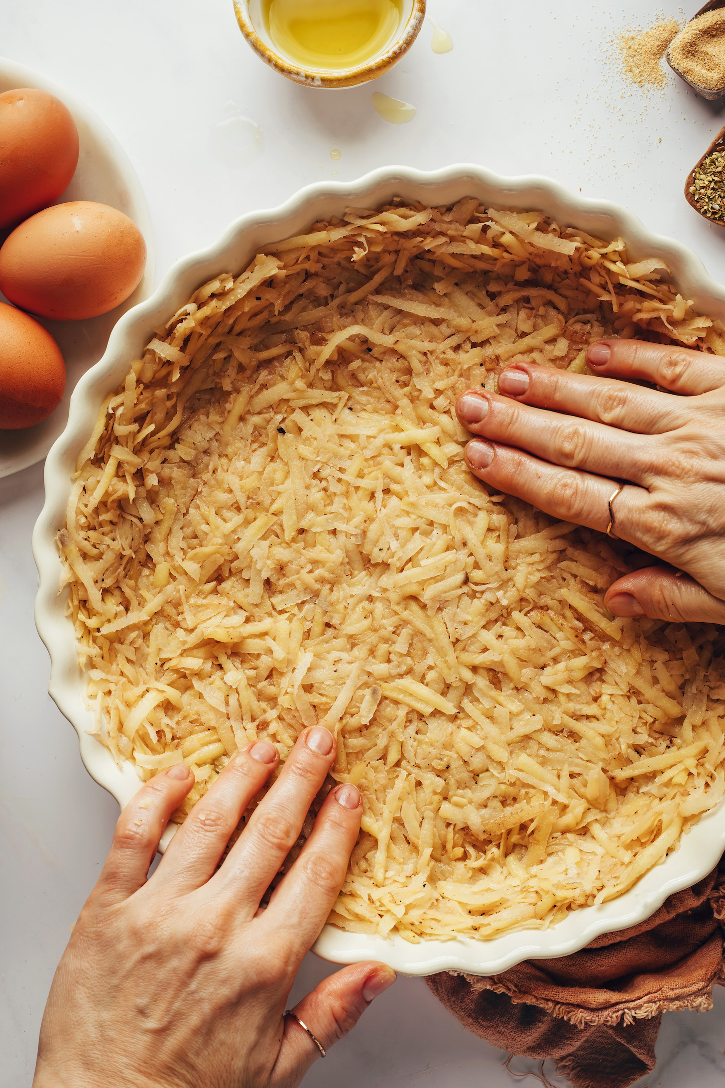 Pressing a potato crust into a pie pan