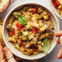 Overhead shot of a bowl of pesto pasta with tofu and veggies